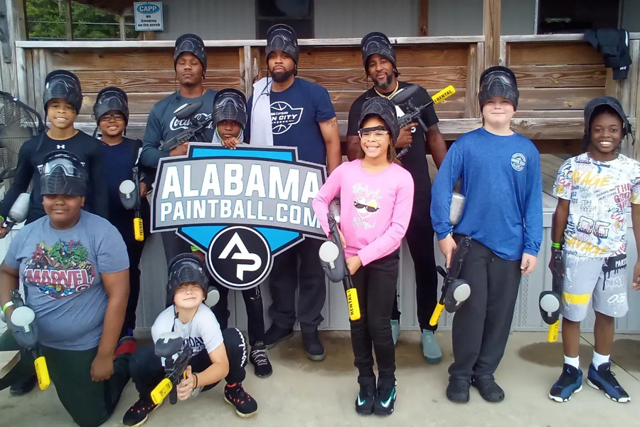A large group of young players with their Alabama Paintball sign
